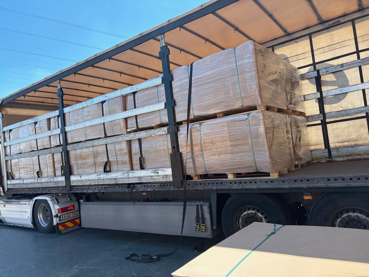 Scania truck with double-stacked pallets of acoustic panels secured for dispatch