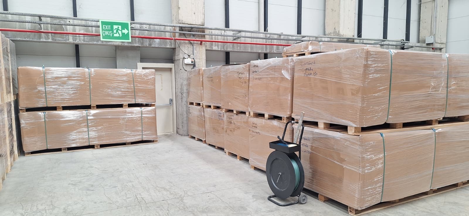 Stacked pallets of wrapped acoustic wall panels ready for bulk wholesale dispatch in a warehouse