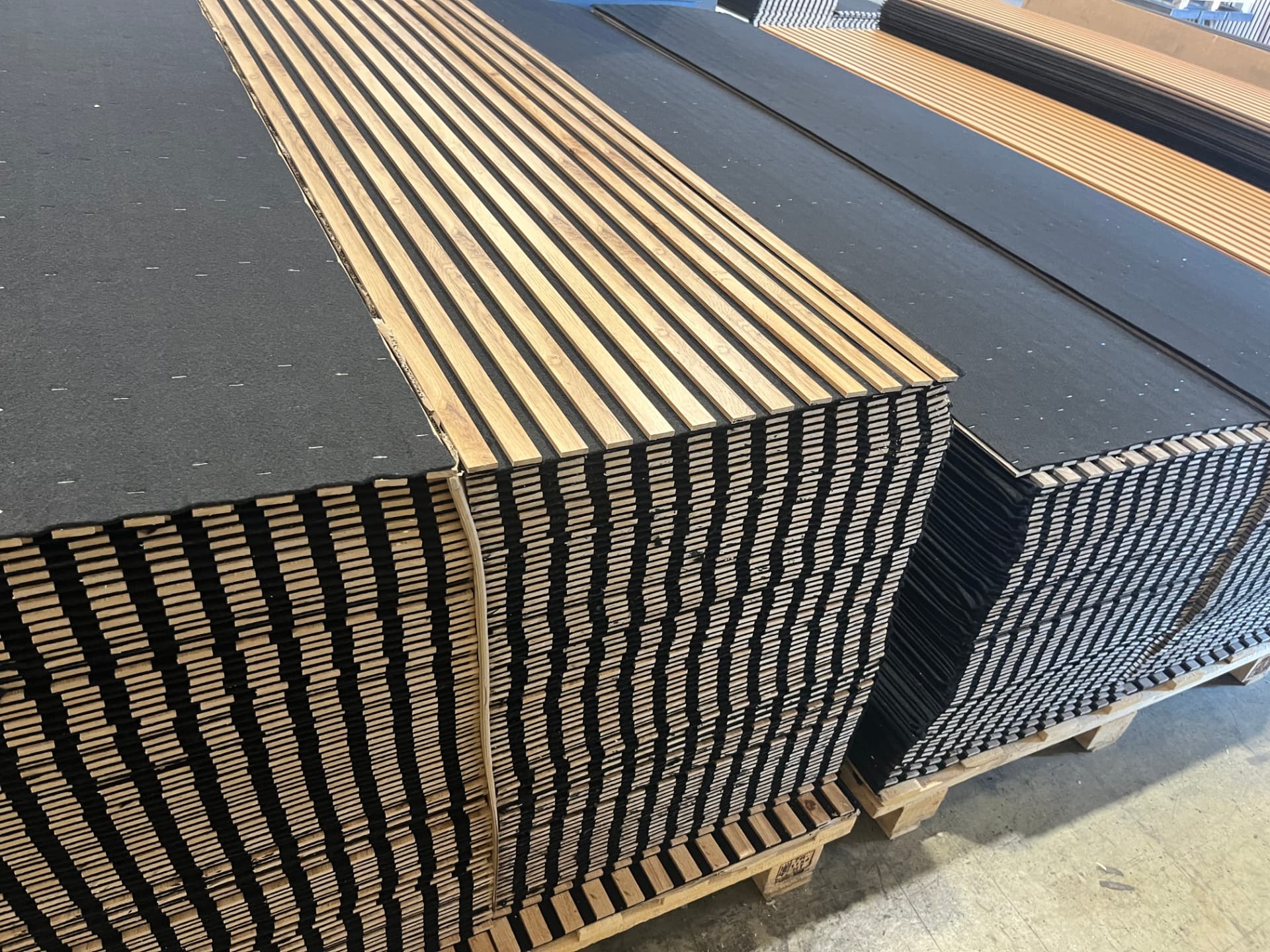 Pallets of teak acoustic wall panels stacked in the SONAVEER dispatch warehouse
